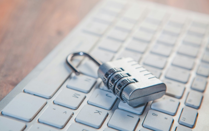 A combination lock rests on a computer keyboard.